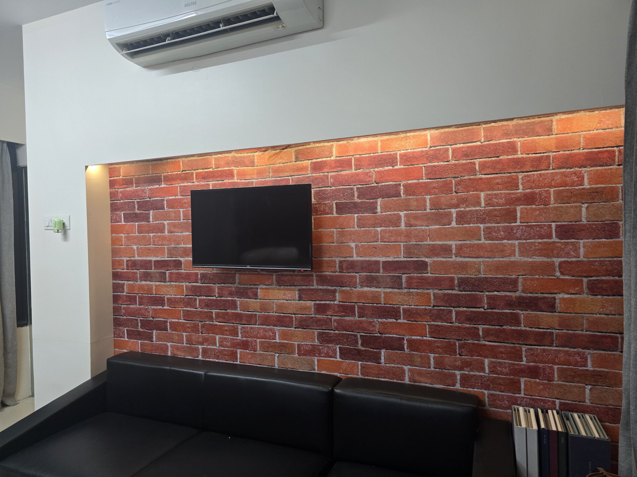 BREIR brick-effect printed wallcovering in a finished office interior, with TV and sofa